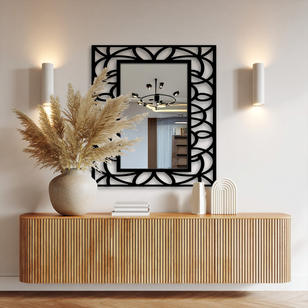 Shadows accentuate the symmetrical floral geometry of this framed decorative mirror, highlighting the light reflecting off its surface.