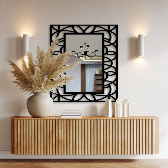 Shadows accentuate the symmetrical floral geometry of this framed decorative mirror, highlighting the light reflecting off its surface.