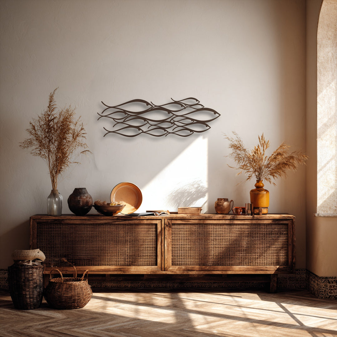 The shadowy deep bronze unique metal wall art of minimalist fish hangs above dark woven storage baskets and rustic pottery.