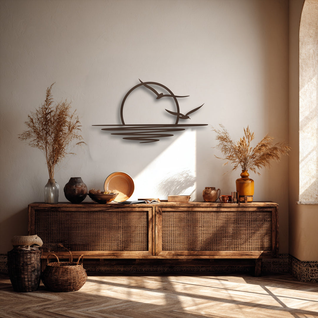 The dark, intricate unique metal wall art featuring a sunset seagull design stands out vividly against the bright, sun-drenched neutral wall.