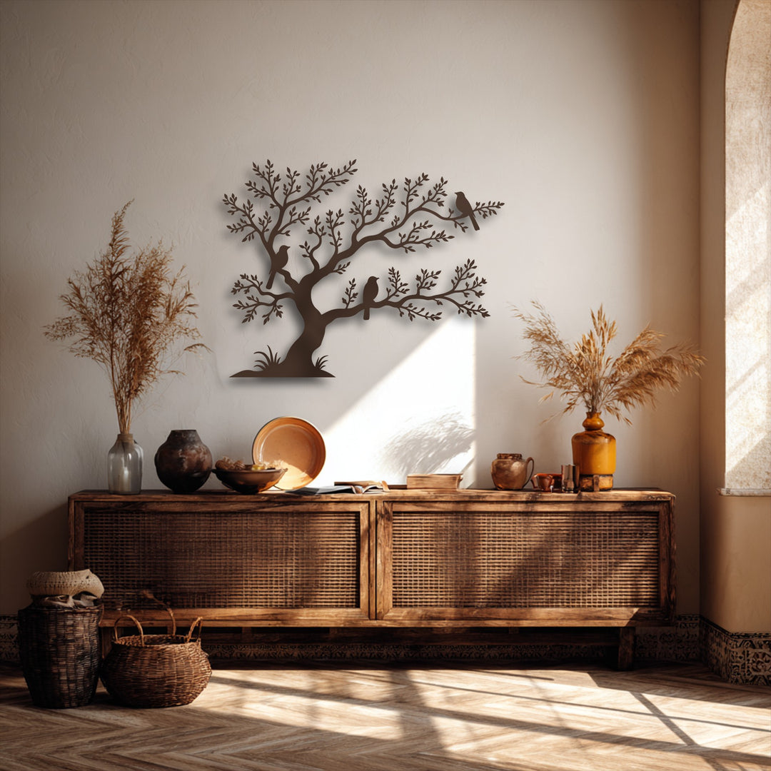 A rustic wooden console table, adorned with vases and bowls, sits before a wall showcasing unique metal wall art featuring birds on tree branches.