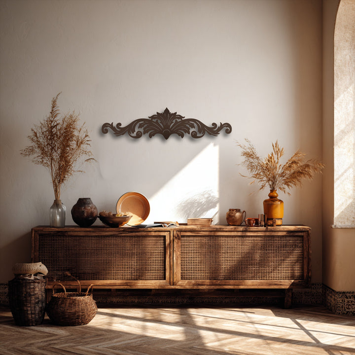 The visual rhythm created by the flowing scrollwork of the brown metal artwork accentuates the bohemian decor above a rattan cabinet.