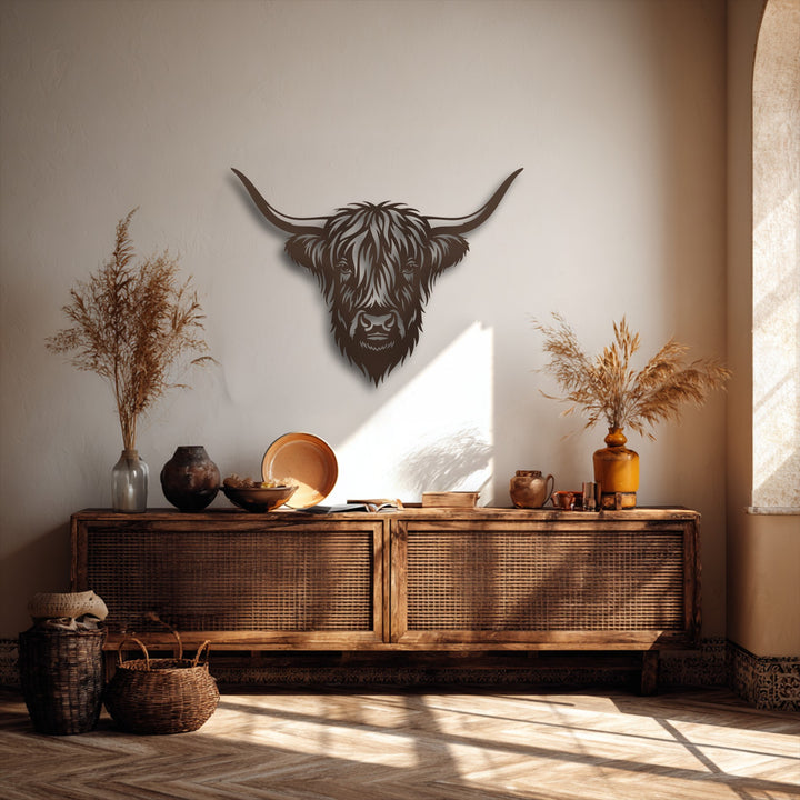 Horizontally oriented decorative metal art of a highland bull head, showcasing its distinctive shaggy shape and wide, curving horns.