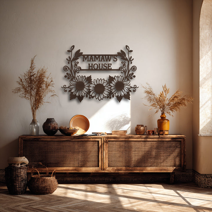 Horizontally oriented metal art for wall features a rectangular 'MAMAW'S HOUSE' sign with intricate sunflower and floral shapes.