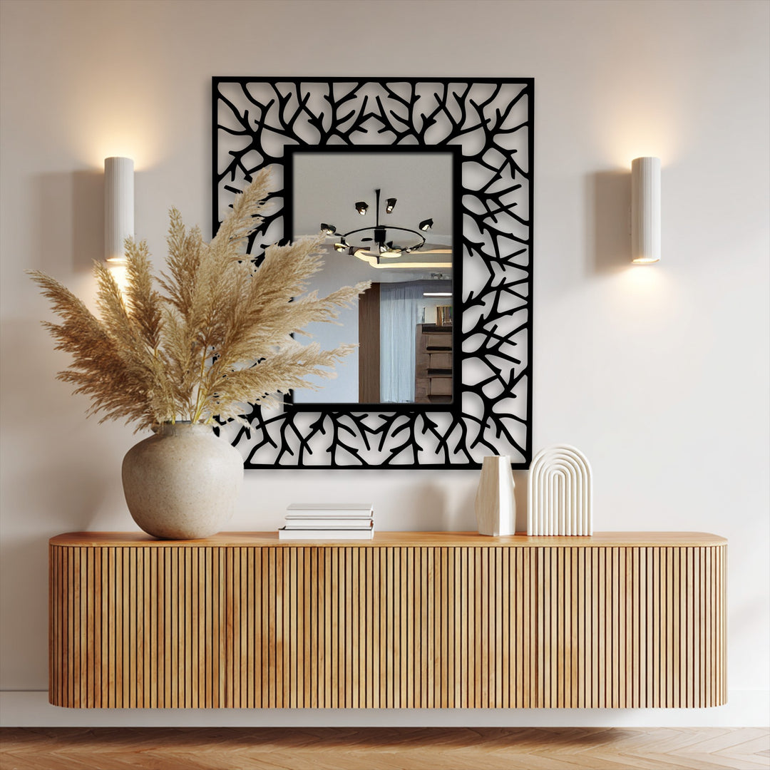 The focal point is the contemporary decorative mirror featuring an abstract branch-textured black metal frame, adding a modern touch with this distinct metal wall decor piece.