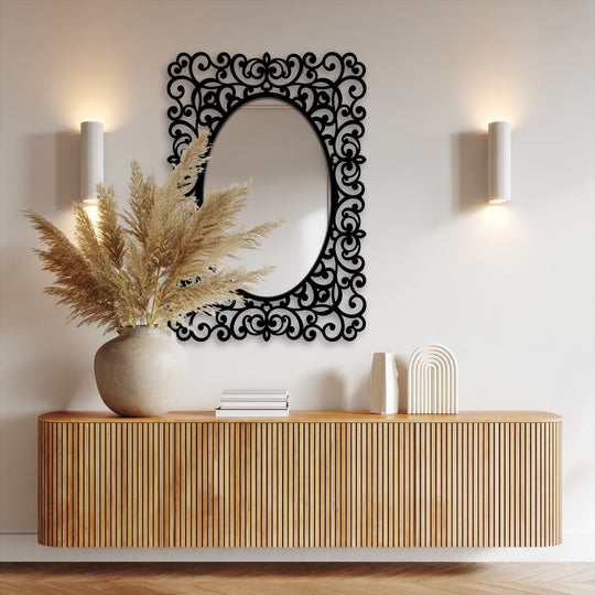 Light glancing off the oval framed wall mirror's reflective surface is the softest element, illuminating the baroque scrollwork details of this decorative framed wall mirror.