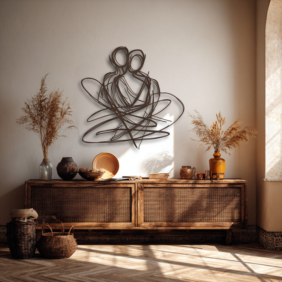 A striking abstract couple metal wall art, crafted as a decorative metal art piece, dominates the wall above a rustic wooden cabinet.