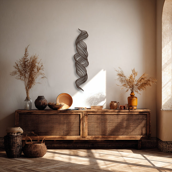 Warm sunlight bathes two woven baskets and a herringbone floor beneath a striking, abstract twist metal art for wall.