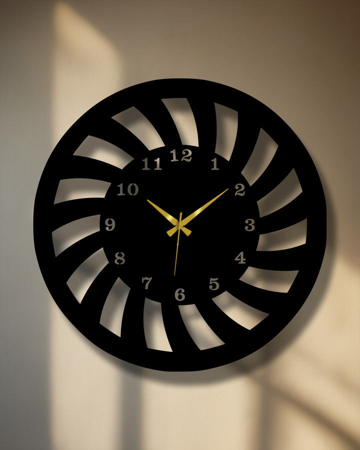 The darkest area highlights the sleek, black spiral motion of this modern dynamic metal wall decor clock with contrasting silver numbers and gold hands.
