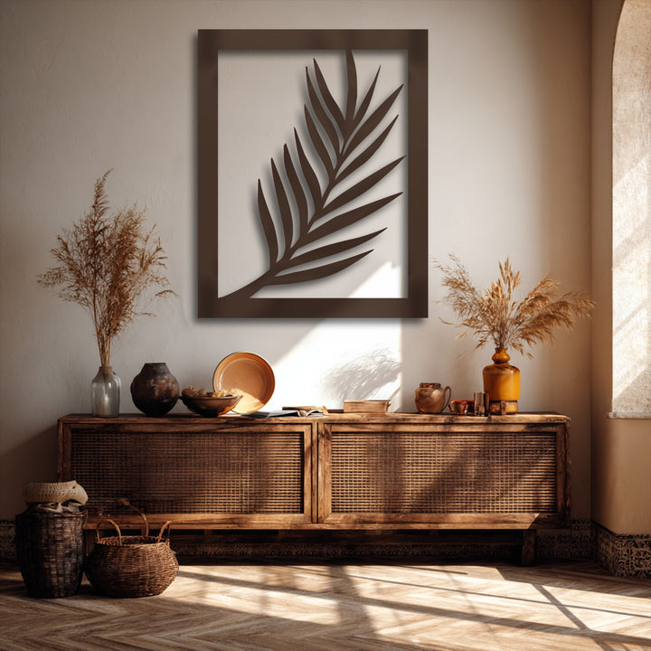 The transition between warm, earthy tones highlights a minimal palm leaf silhouette metal artwork, with deep bronze contrasting against lighter walls.
