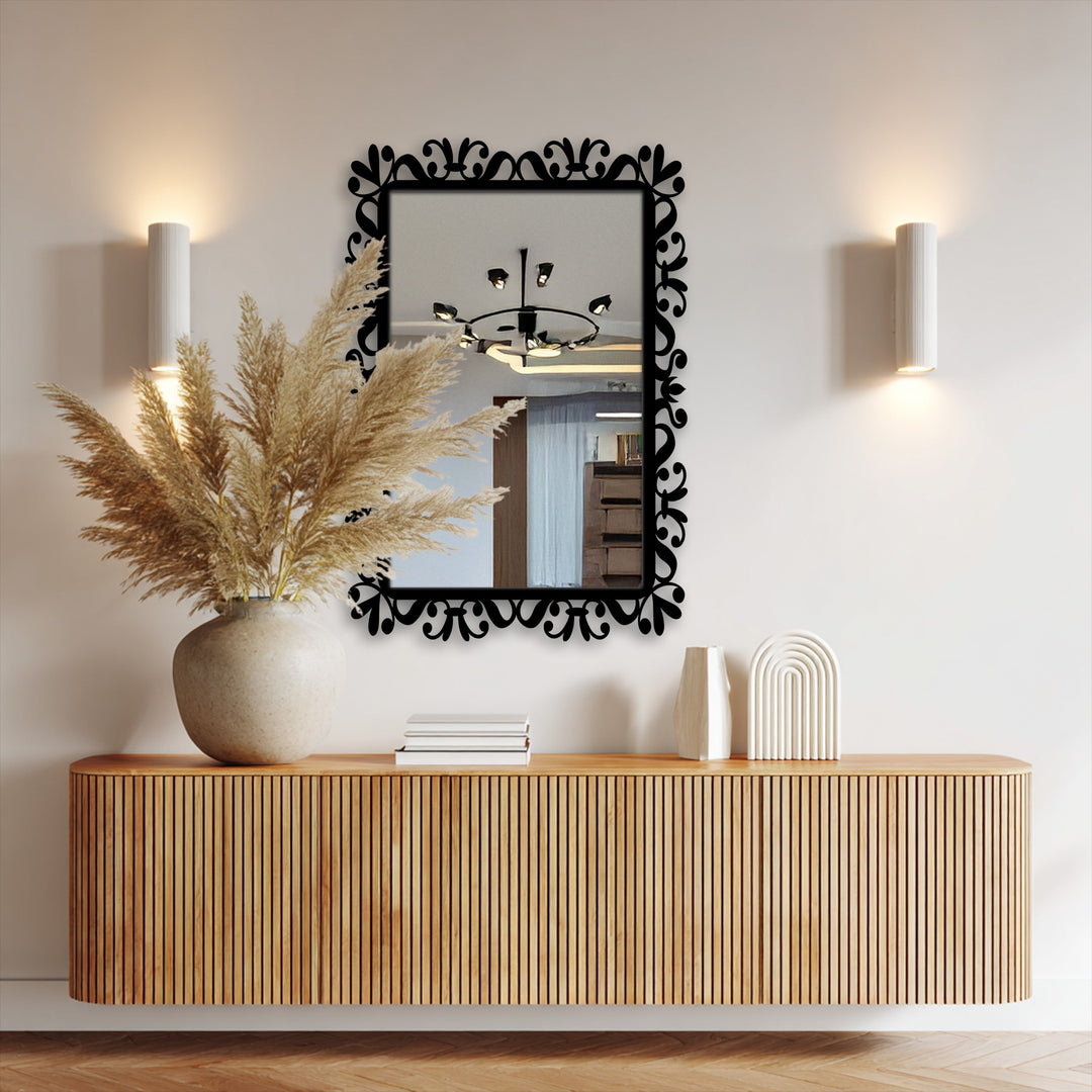 Low color saturation in the bathroom mirror highlights the black vine scroll frame, adding a minimalist, monochromatic touch to the reflected space.