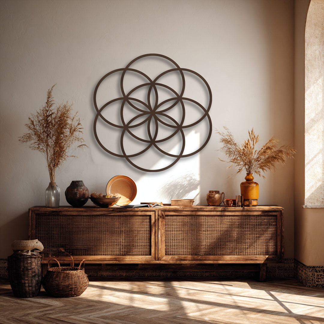 Delicate, wispy dried botanicals softly grace vases on a wooden console, beneath the striking Flower of Life metal art for wall.