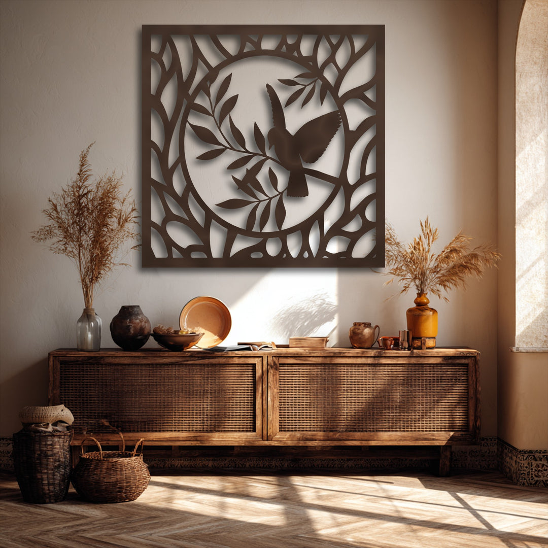 A square metal artwork panel features a striking central circular design depicting a graceful bird amidst intertwining branches.