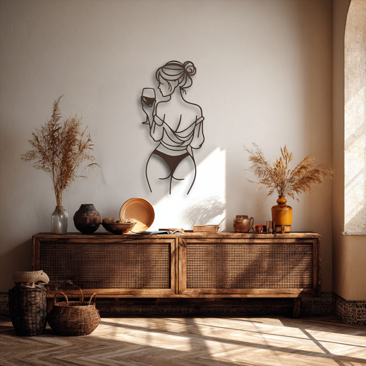 A prominent dark bronze minimalist line art woman holding a wine glass decorative metal art piece anchors the warm-toned room.