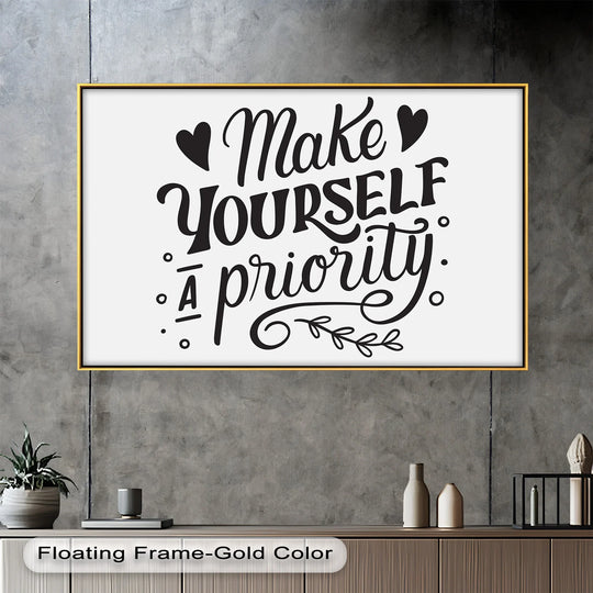 Neutral color temperature highlights the black and white 'Make Yourself a Priority' oil painting artwork with a warm gold floating frame on a gray wall.