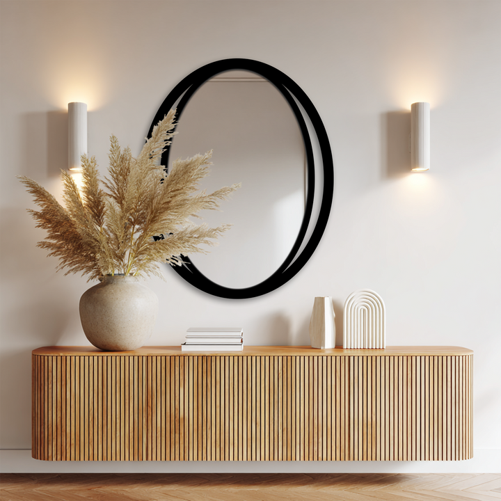 The sleek modern dual frame of the double eclipse oval framed wall mirror commands attention as the central subject in this minimalist decor.