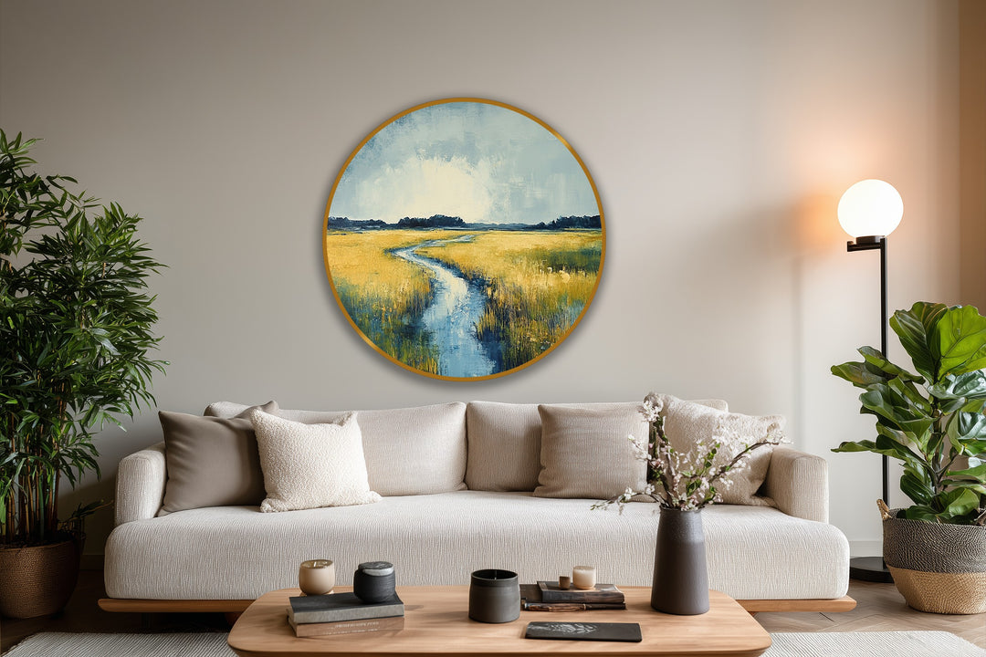 Gray wall negative space surrounds the circular golden horizon of the serene meadow river oil painting wall art, creating a calming focal point.