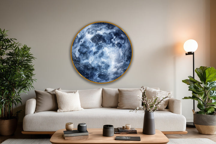 Foreground view of a coffee table with books and candles in front of a Midnight Nebula abstract round oil painting wall art, offering a serene home decoration.