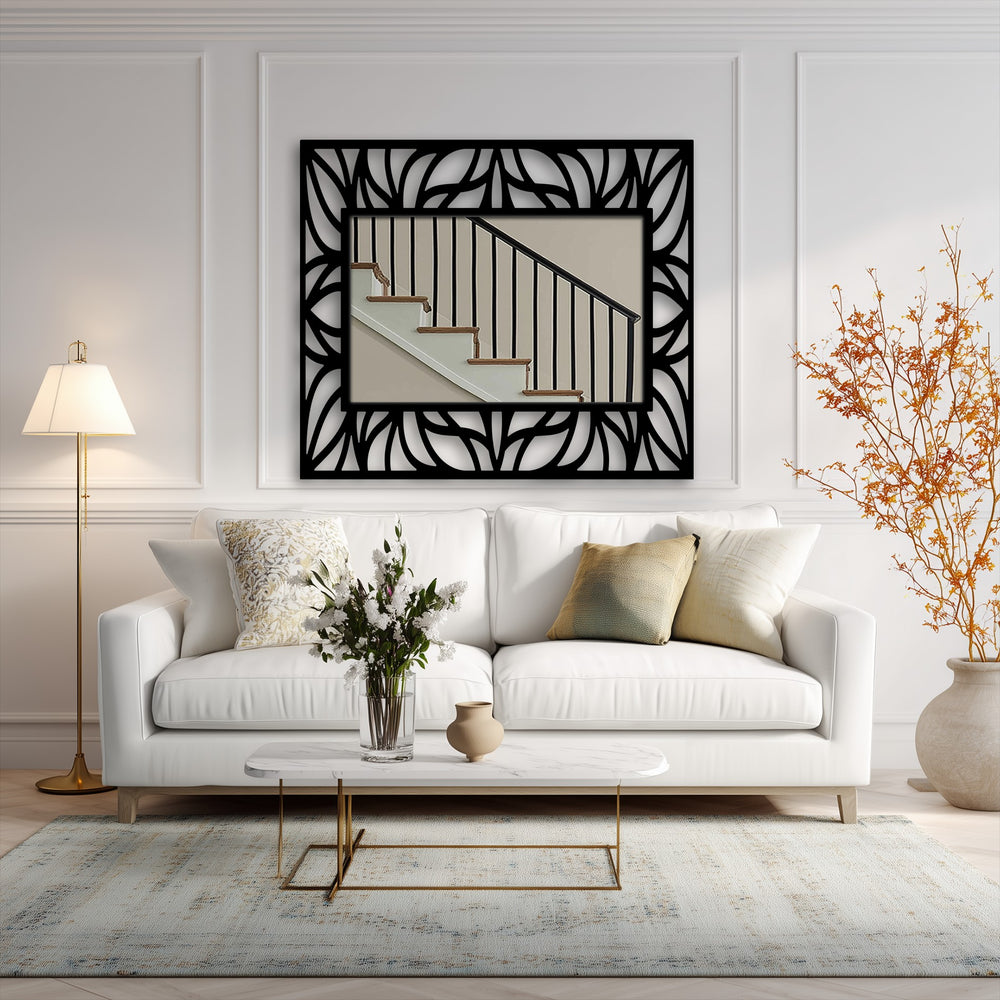 The stillness of the room is punctuated by the bold, black lines of the organic leaf pattern frame and the reflective surface of this modern mirror.
