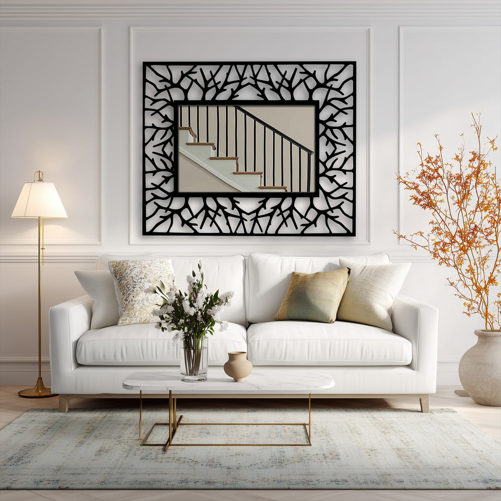 Layers of wall decor bring depth with the abstract branch texture, black metal artwork frame enhancing the central mirror's reflection of a staircase.