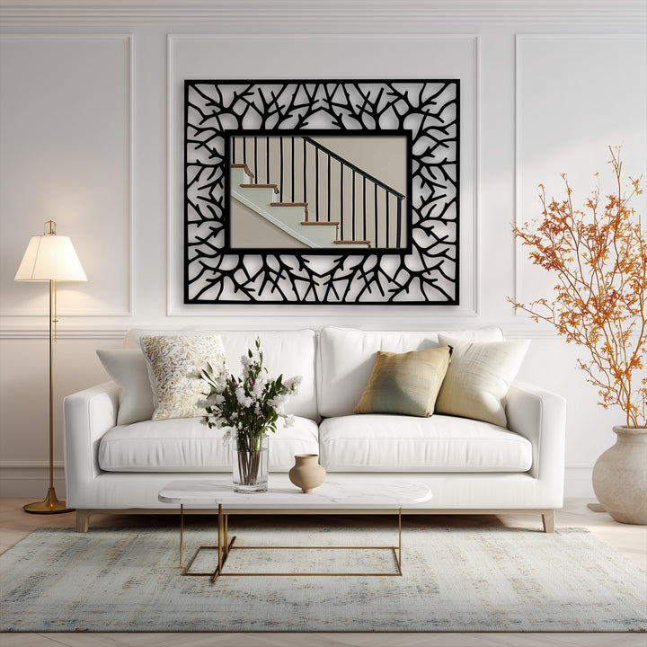 Layers of wall decor bring depth with the abstract branch texture, black metal artwork frame enhancing the central mirror's reflection of a staircase.