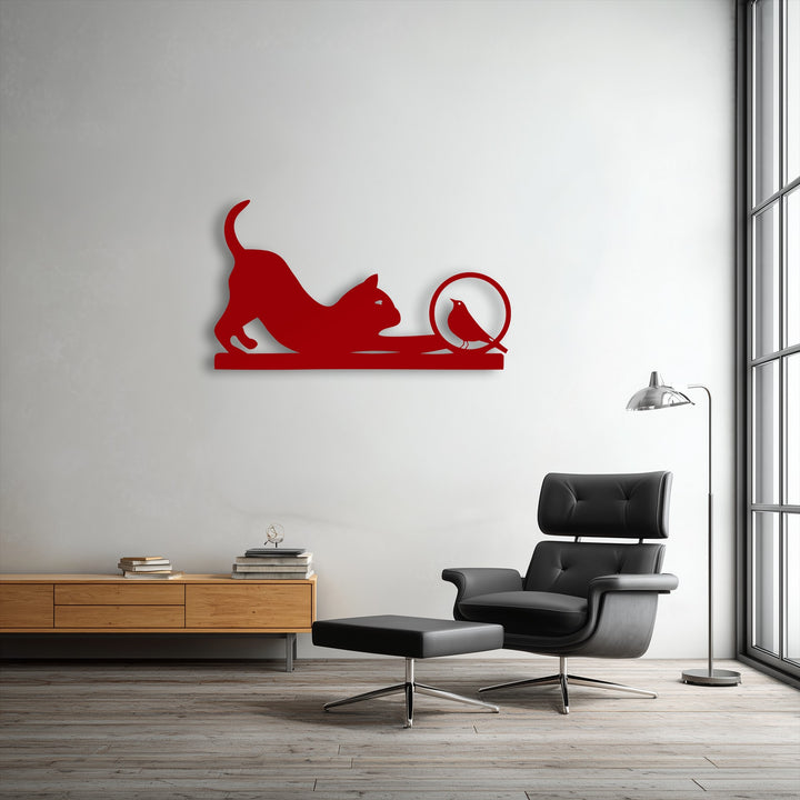 Vibrant red decorative metal art features a playful cat reaching for a curious bird silhouette, enhancing modern home decor.