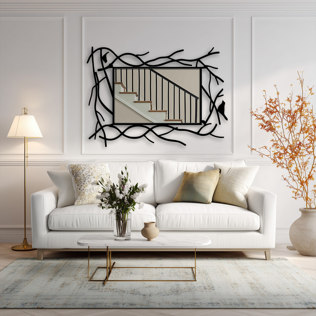 Framed by geometric black metal branches, this modern mirror for wall decor showcases a stairwell reflection, complemented by a stylized bird accent.