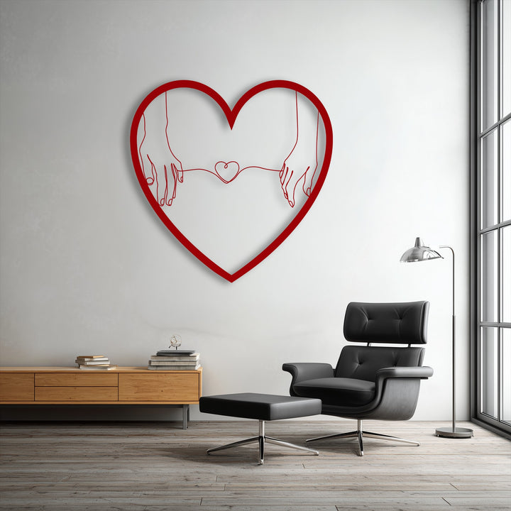Bold red decorative metal art featuring minimalist connected hearts holding hands, creating a love line design on a white wall.