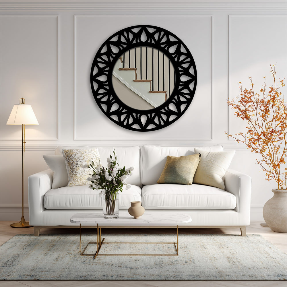 Organic forms define the floral cutout pattern of this round, black metal statement mirror, offering unique metal wall art for modern home decor.