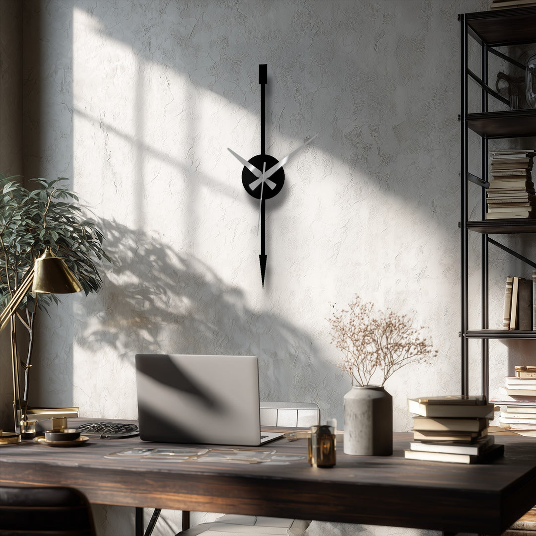 Sunlight highlights the decorative metal art clock, creating a gentle transition between the stark black of its arrow and the wall’s textured gradients.