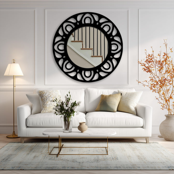Surface textures exhibit the sleek, reflective glass and the intricate, matte black finish of this modern pattern ring framed wall mirror.