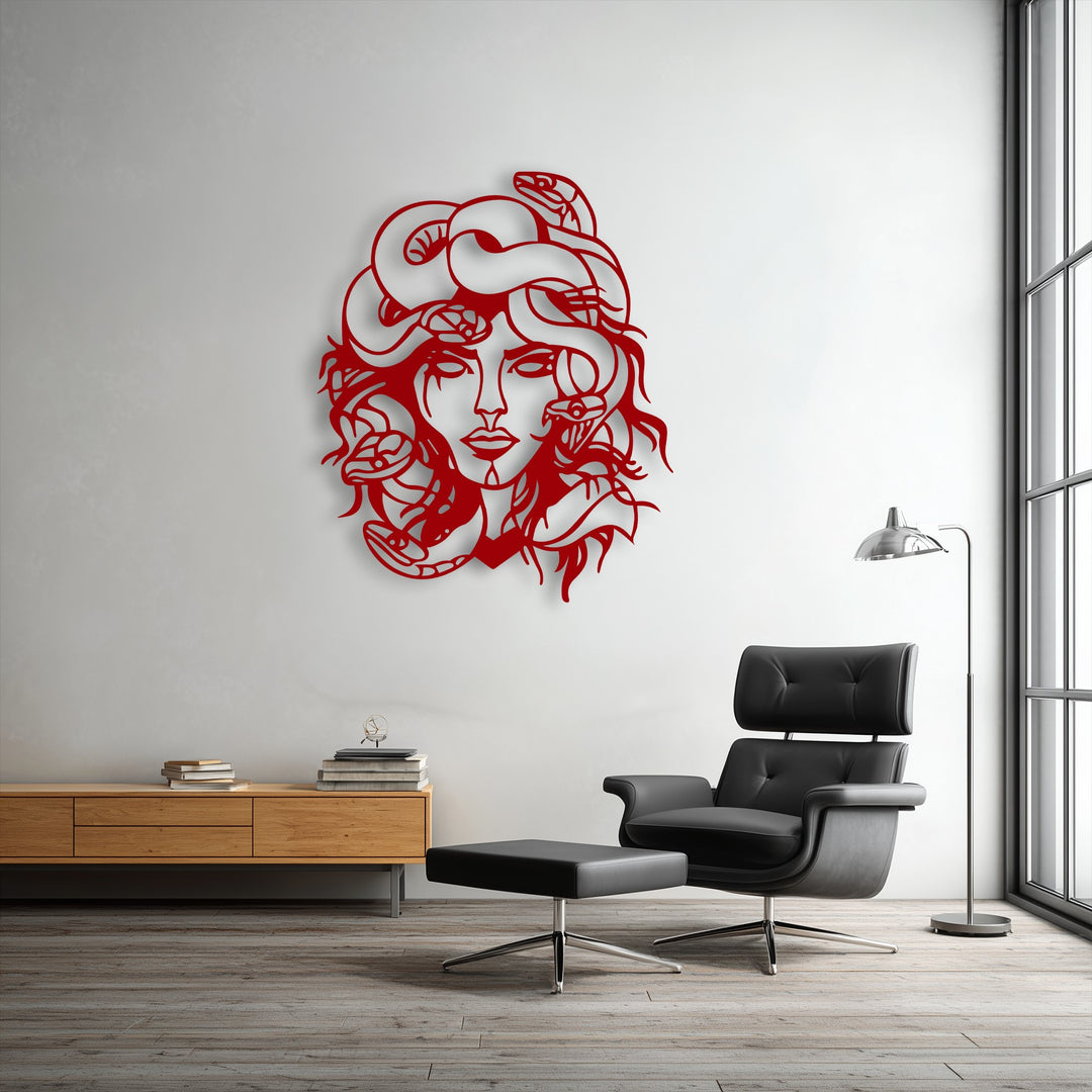 Highly saturated vibrant red decorative metal art of Medusa, a mythological snake goddess, boldly stands out on a bright white wall.