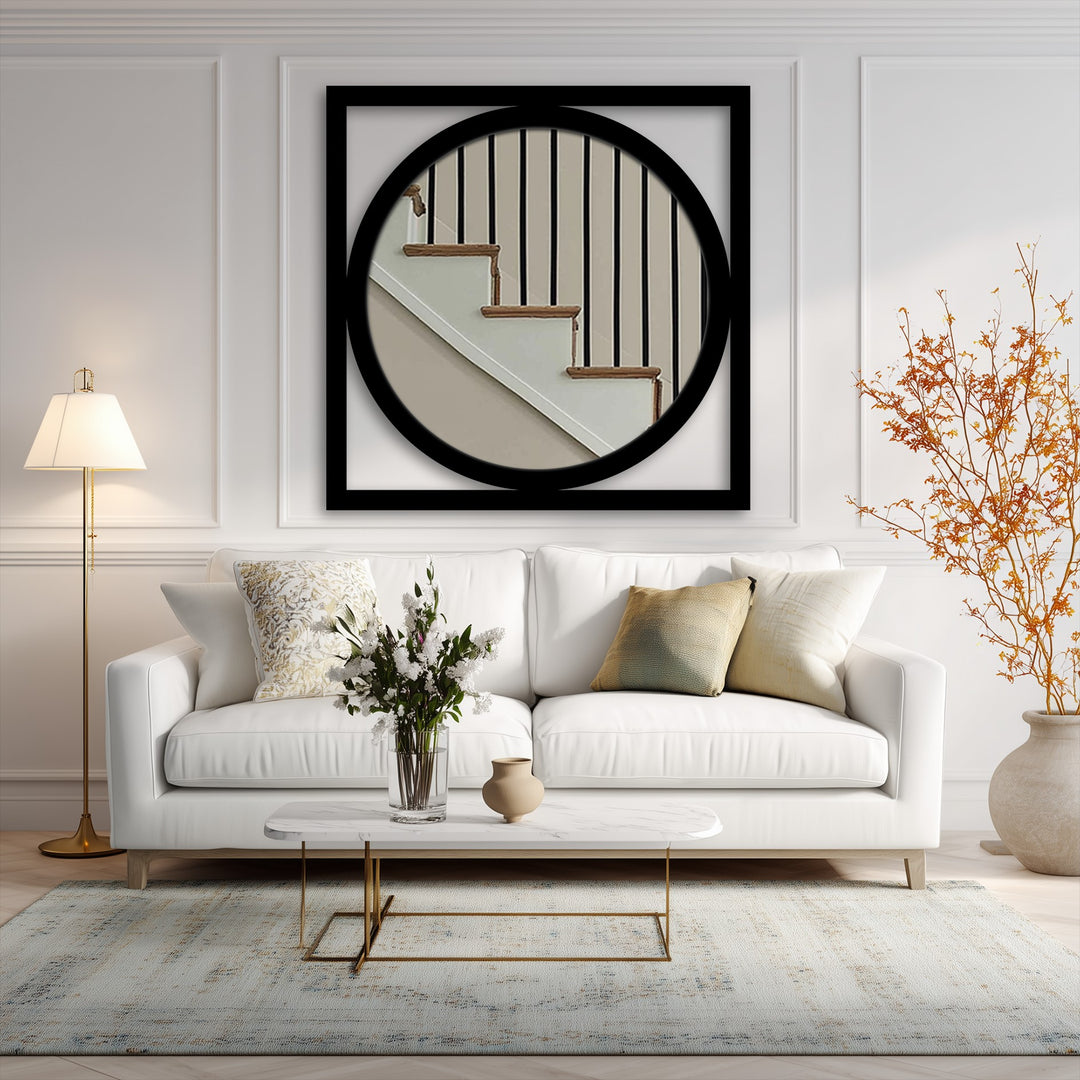 Square orientation shows a round framed wall mirror with a modern black metal frame, a piece of striking metal artwork.