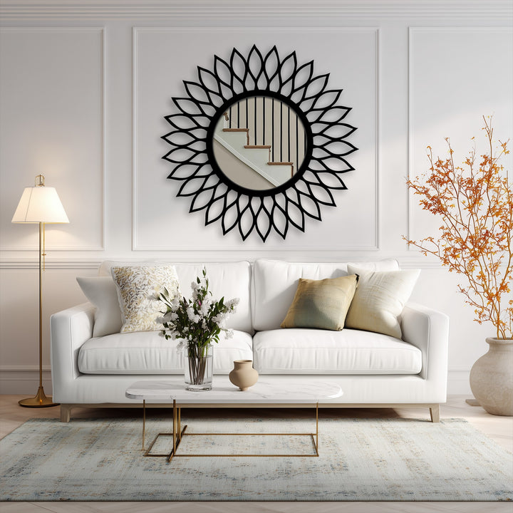 Low color saturation highlights the black radiant leaf halo frame of this decorative metal art mirror reflecting a staircase in a neutrally toned room.