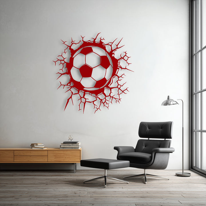 Organic forms of jagged, dynamic cracks explode around a vibrant red soccer ball, creating unique metal wall art with a breaking wall effect.