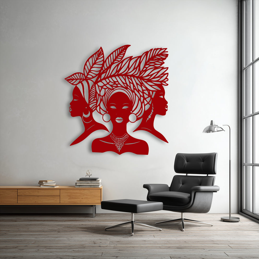 Featuring depth and intricate layers, this red African Queen Silhouette metal wall decor depicts three figures with leaf designs, casting subtle shadows.