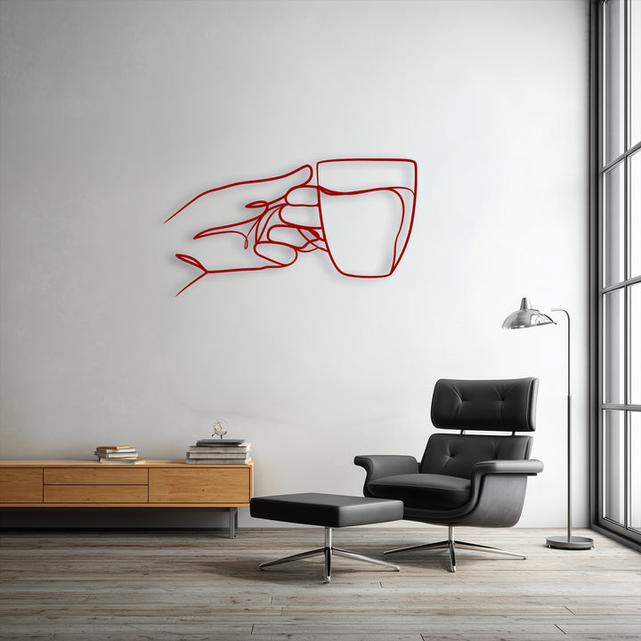 The darkest area reveals a sophisticated black leather armchair and ottoman below minimalist hand holding cup line art metal wall decor.
