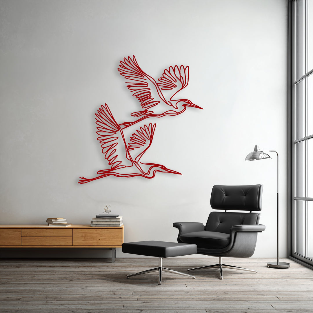 The cool, inviting color temperature highlights the unique metal wall art featuring graceful flying herons against a crisp white wall.