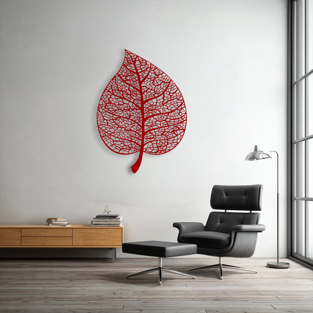 The stillness of the room is captured by the intricate red botanical leaf metal artwork on the white wall, with a sleek black chair beside it.