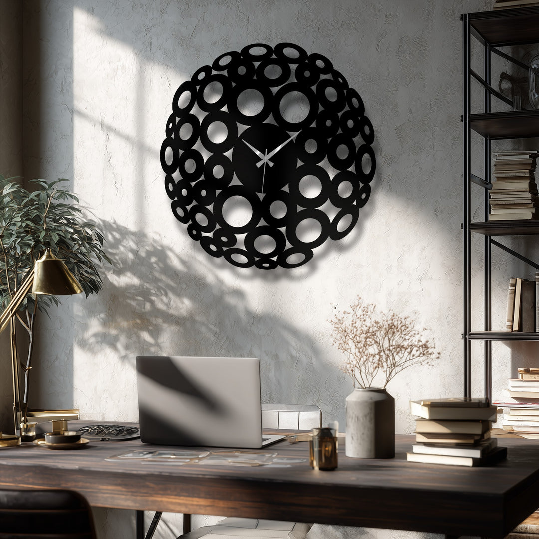 The darkest area of the modern abstract ring design of this metal wall clock shows the unique metal wall art circle cutouts casting a dark shadow on the nearby wall.
