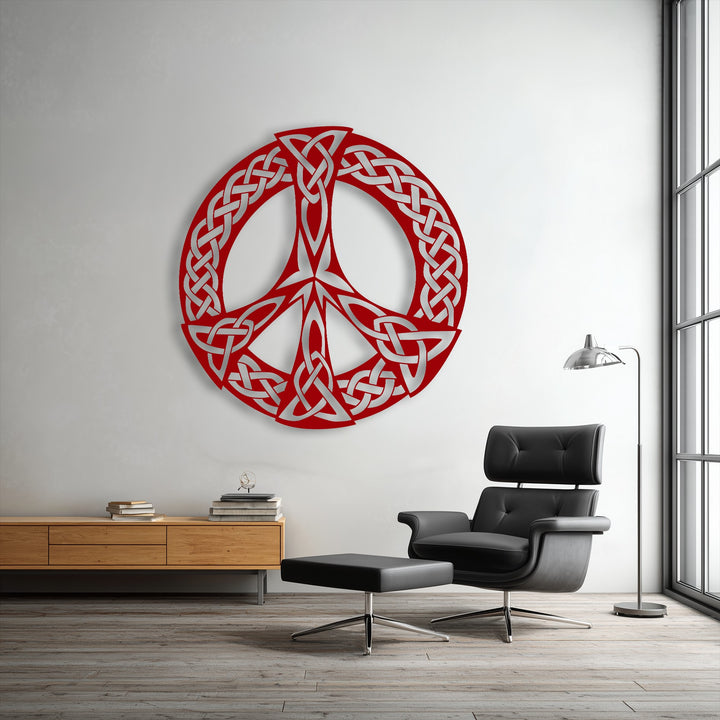 An abstract red and silver Celtic knot peace symbol, handcrafted as decorative metal art, features intricate intertwining patterns.