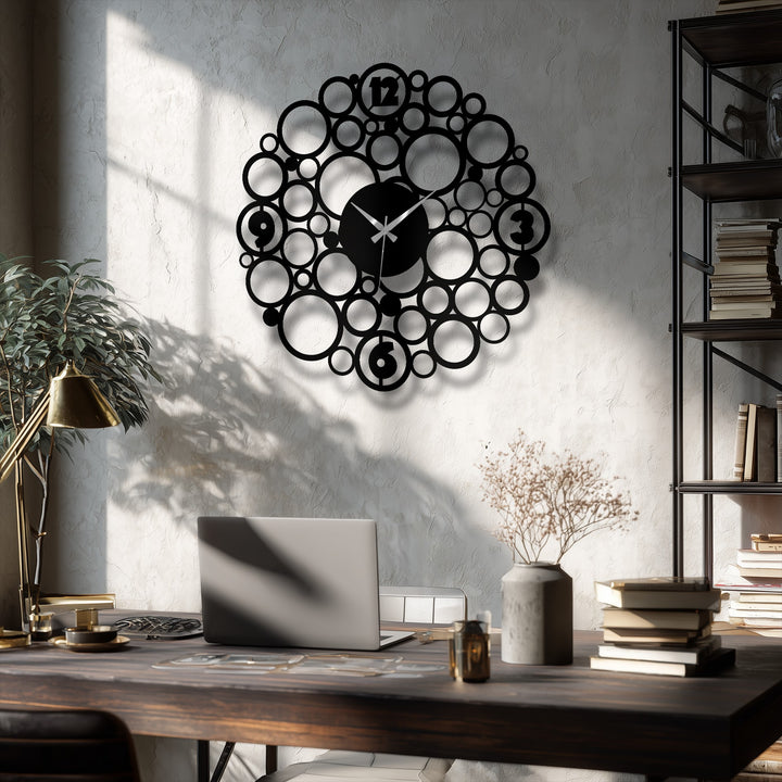 Round metal artwork wall clock featuring a bubble design and an abstract shape is displayed in a contemporary, almost centered orientation.