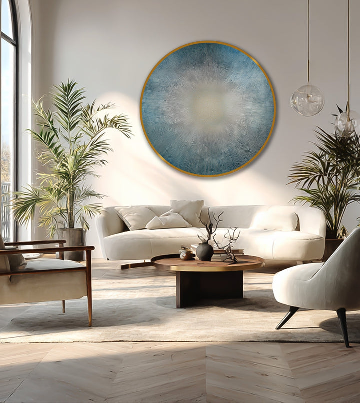 The stillness of this contemporary space is complemented by the round oil painting artwork, featuring a radiant sunburst design in calming blues.