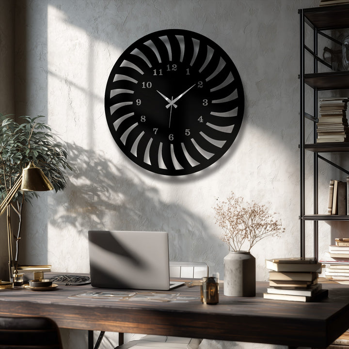Striking color contrast is evident with a black radial pattern metal wall decor clock sharply defined against the textured, sunlit white wall.