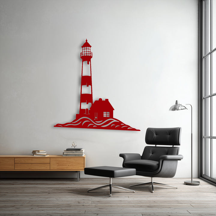 A vibrant red coastal lighthouse and house silhouette with undulating waves forms a striking metal artwork on a light gray wall.