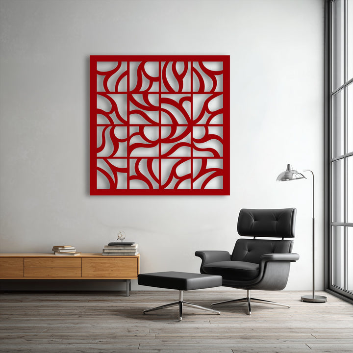 Striking color contrast is evident in the bold red abstract geometric metal wall decor against the neutral white wall in a modern living space.
