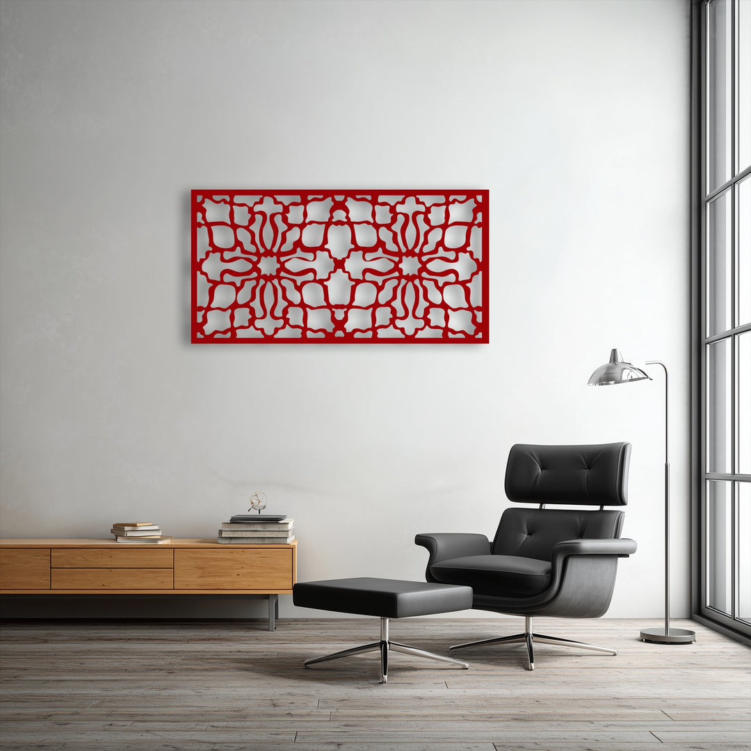 The vibrant red ornamental geometric decorative metal art sharply contrasts with the crisp white wall, defining a distinct color transition.
