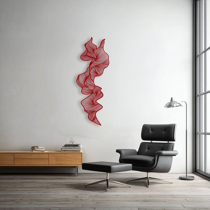 The vibrant red of the vertical abstract flow metal wall decor subtly transitions to soft shadows against the bright white wall.