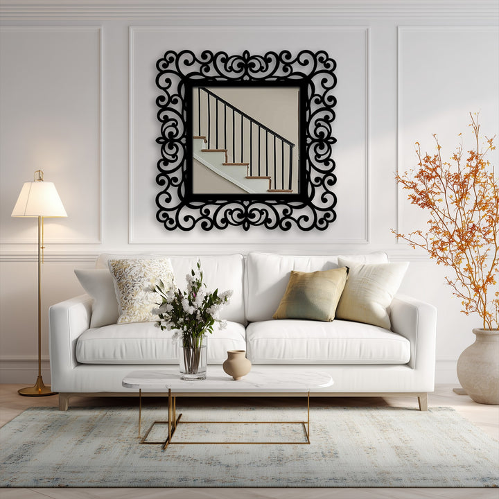 The darkest area defines the ornate scrollwork on the black metal artwork, accentuating the frame of this modern wall mirrors reflecting an interior staircase.
