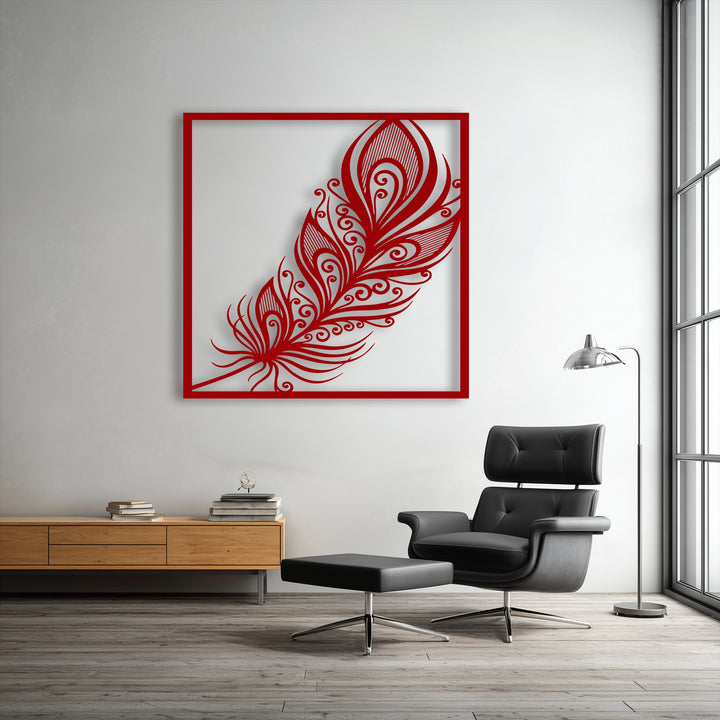 Striking light casts a deep shadow behind the intricate red ornate feather unique metal wall art, highlighting its elegant swirl plume design.